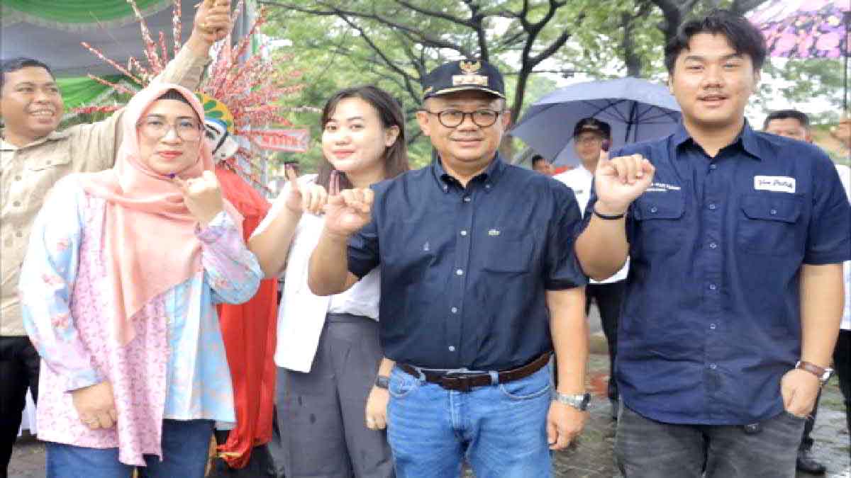 Ditengah Rintik Hujan, Pj Wali Kota Bekasi dan Istri Nyoblos di TPS 011